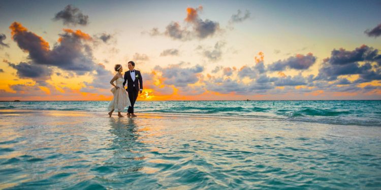 Man and Woman Walking of Body of Water
