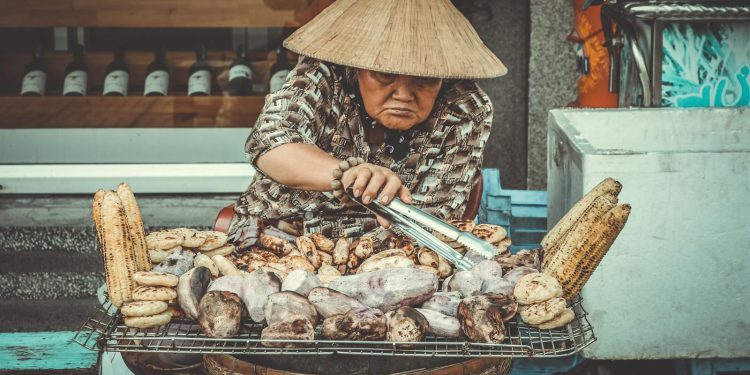 Woman Selling Grilled Root Crops