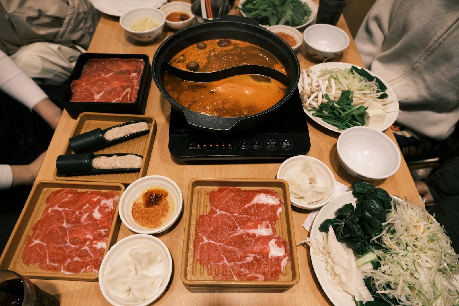 People Sitting at a Table Full of Food in a Restaurant