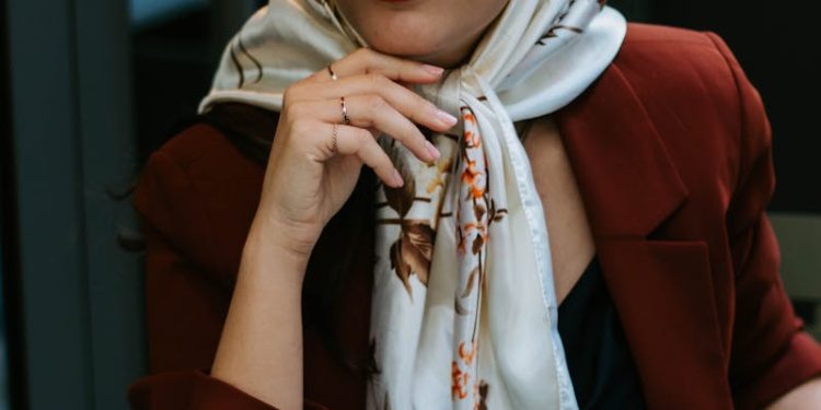 Stylish woman wearing a hijab and sunglasses enjoys coffee in Istanbul café.