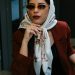 Stylish woman wearing a hijab and sunglasses enjoys coffee in Istanbul café.