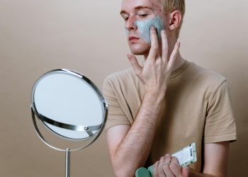 Man in Brown Crew Neck T-shirt Holding Round Mirror