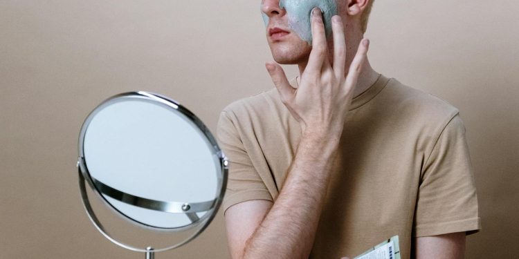 Man in Brown Crew Neck T-shirt Holding Round Mirror
