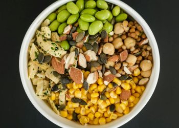 Top view of bowl full of healthy tasty fresh corn and beans prepared for cooking salad on black background