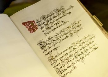 Old opened book with calligraphic inscription