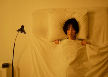 A Woman Lying on the Bed with Blanket