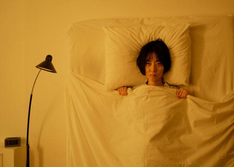 A Woman Lying on the Bed with Blanket