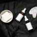 Brown Glass Bottles on Black Textile Beside Gua Sha and Soap