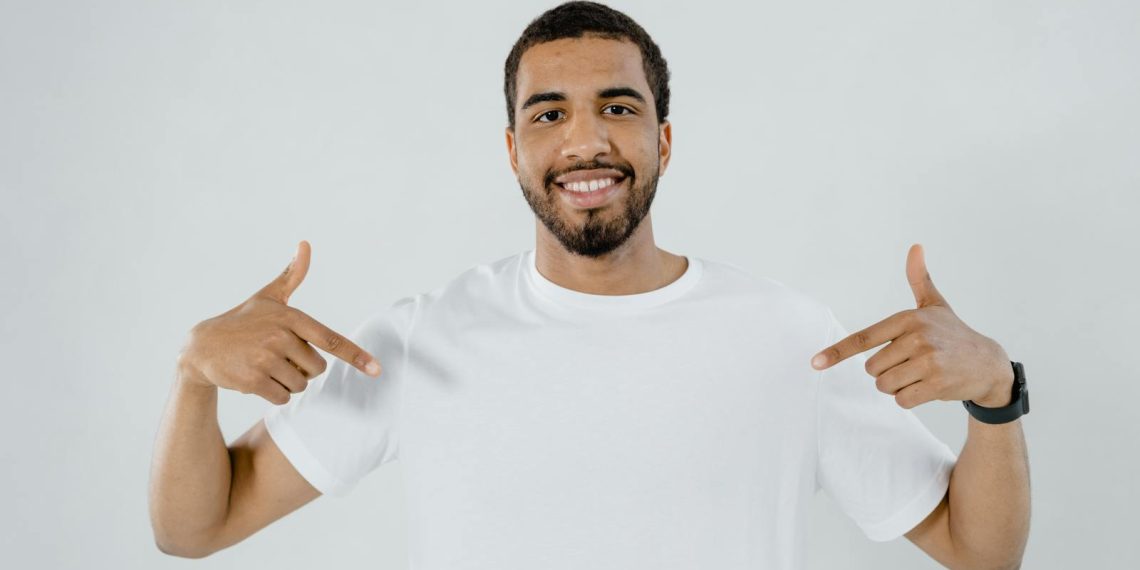 A Bearded Man Pointing at His Plain White Shirt