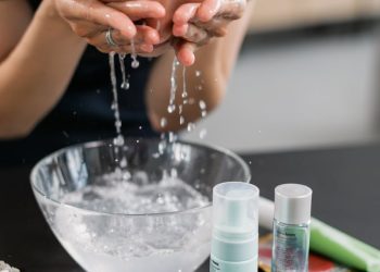 Woman in Black Shirt Washing her Face with Water