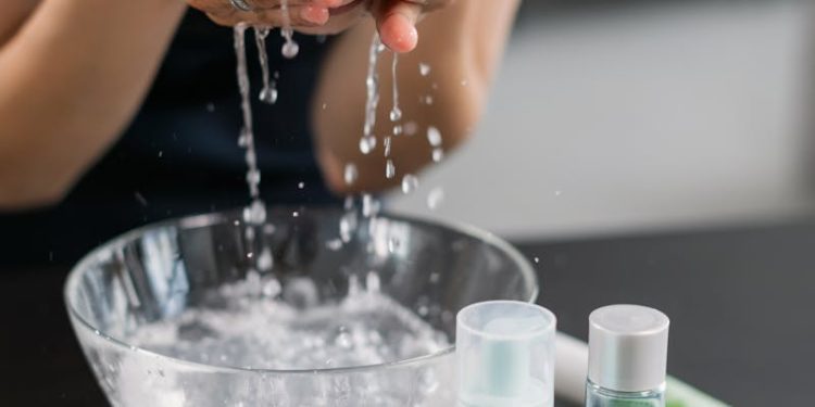 Woman in Black Shirt Washing her Face with Water