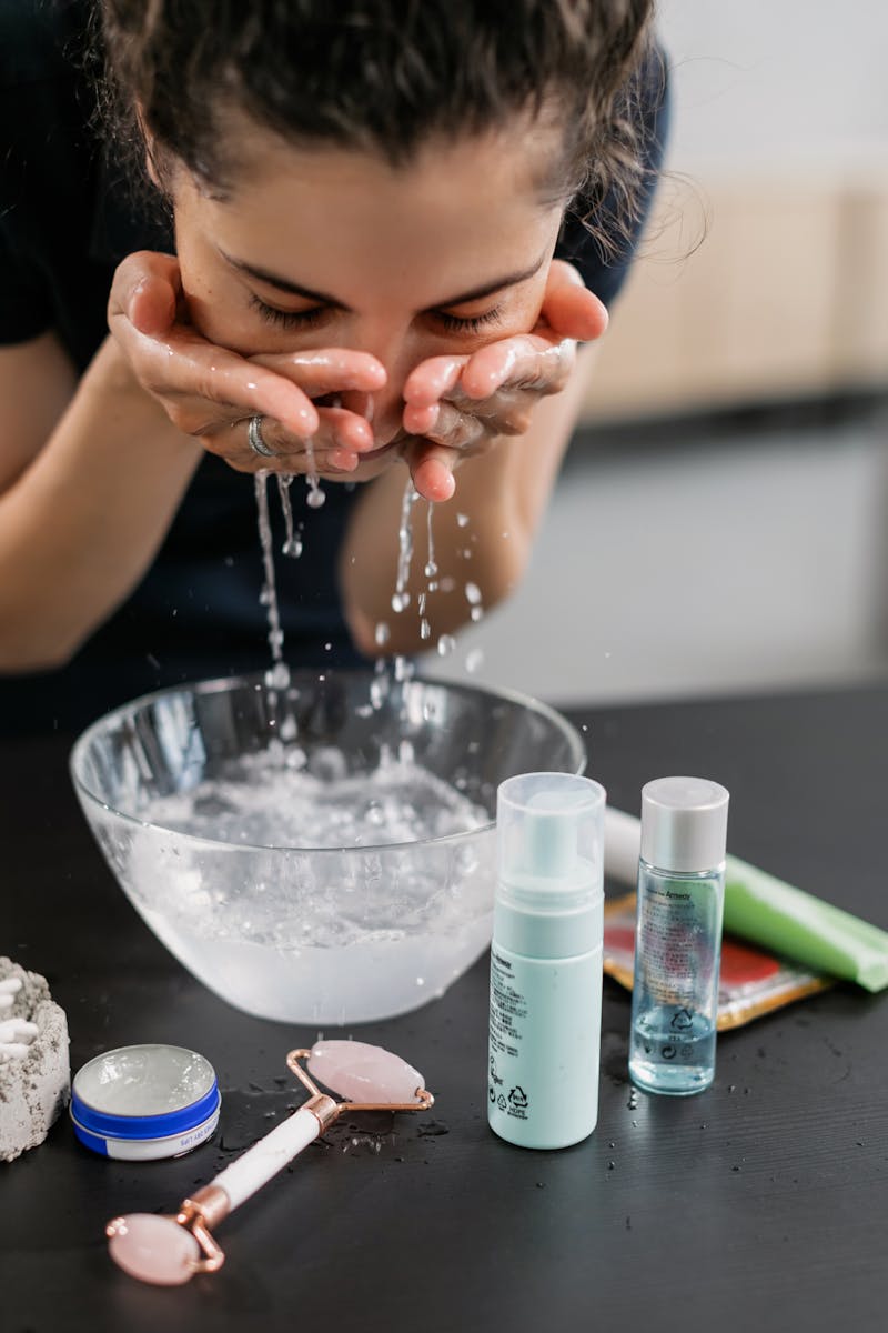 Woman in Black Shirt Washing her Face with Water