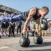 Man in Black Tank Top Doing Push Ups with Kettlebell on Mouth