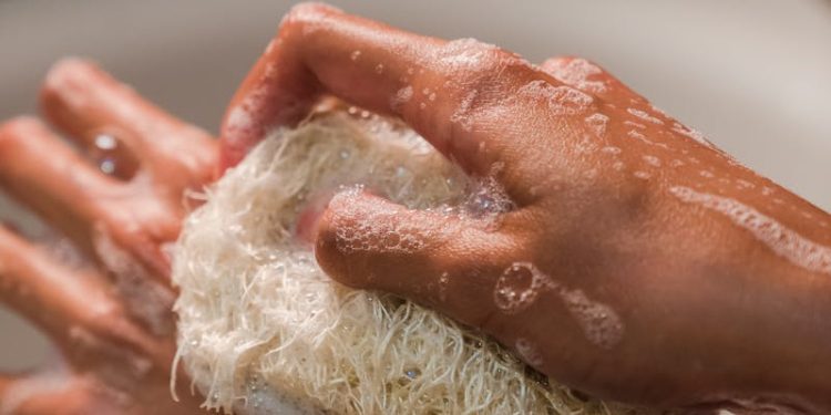 Close-Up Photo of a Person Using a Body Scrub